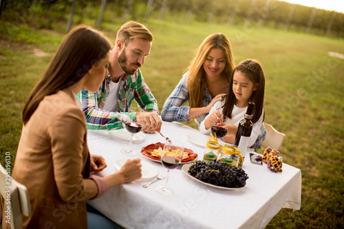 Young people enjoy dinner and wine tasting in the vineyard