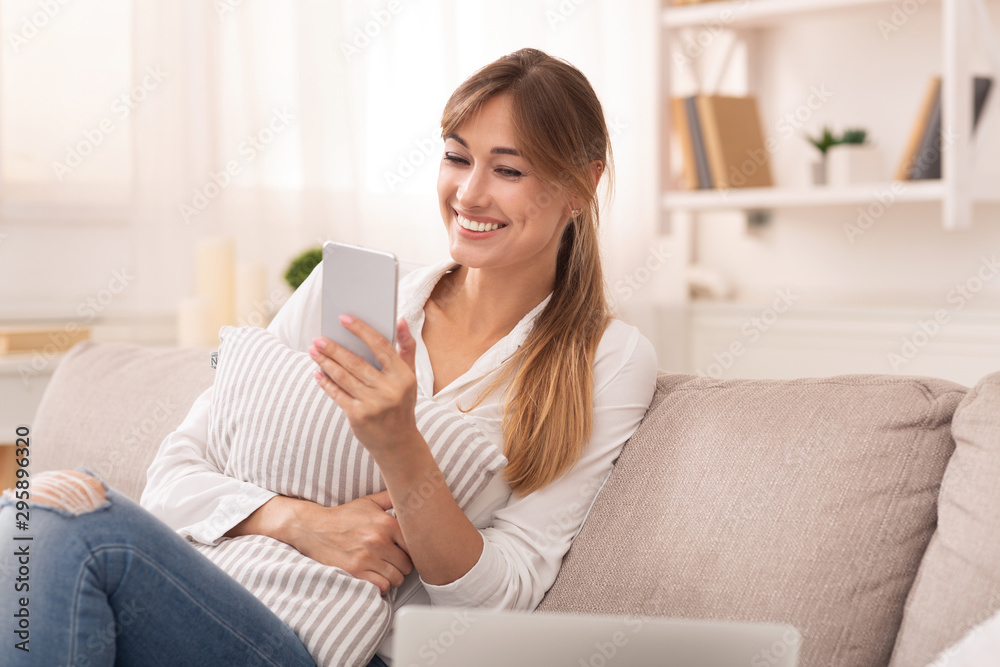 Positive Lady Using Smartphone Texting Sitting On Couch At Home Positive Lady Using Smartphone Texting Sitting On Couch At Home