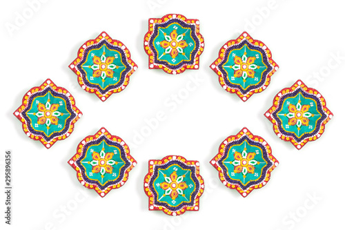 Happy Diwali - Clay Diya lamps lit during Dipavali, Hindu festival of lights celebration. Colorful traditional oil lamp diya on white background. Copy space for text. © Oranuch