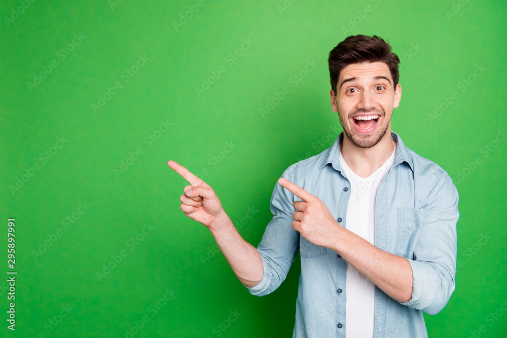 Photo of cheerful positive handsome man pointing at empty space expressing ecstatic emotions on face with bristle isolated over green vivid color background Photo of cheerful positive handsome man pointing at empty space expressing ecstatic emotions on face with bristle isolated over green vivid color background