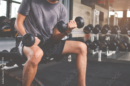 Obraz na plátně Closeup of a thin man doing exercises with dumbbell