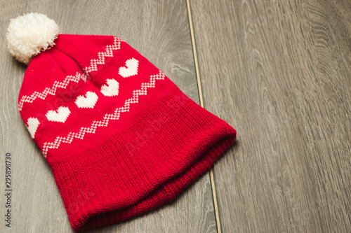 Red and white knitted winter hat with love hearts and bobble