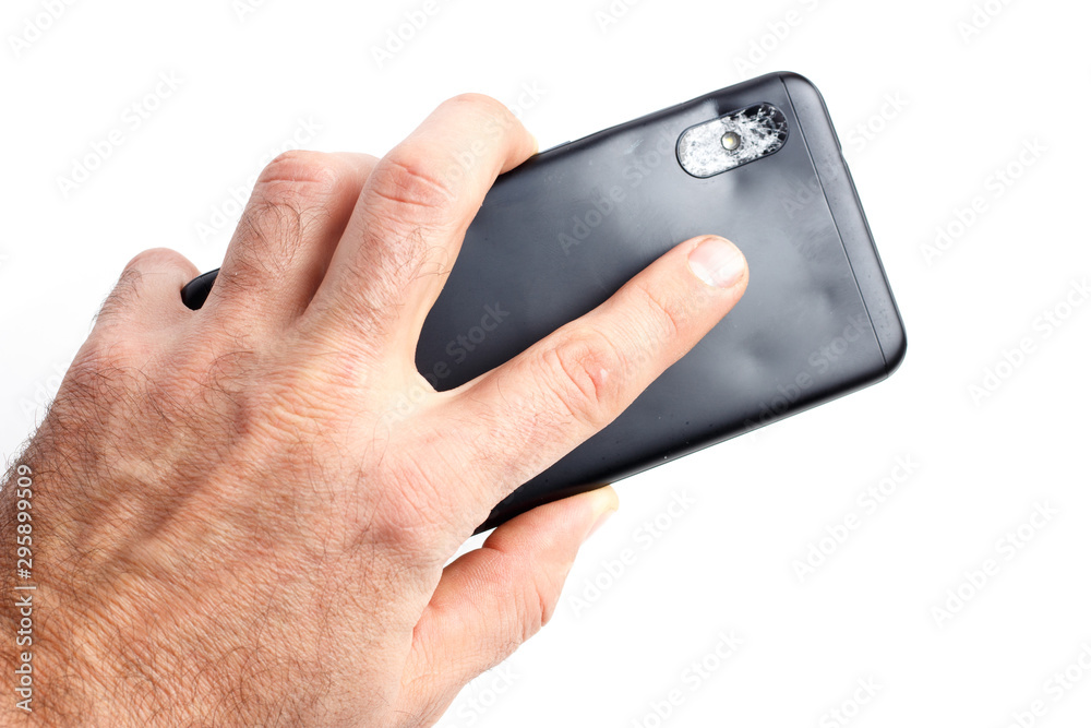 Hand holds a broken smartphone on a white background Hand holds a broken smartphone on a white background