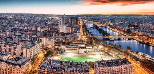 Paris city skyline rooftop view with River Seine at night, France. Evening panorama.