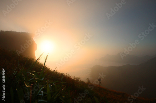 Beautiful silhouette landscape valley of mountain with foggy and mist in winter of sunrise shining on the sky at Phu Chee Fah hill northern of Thailand