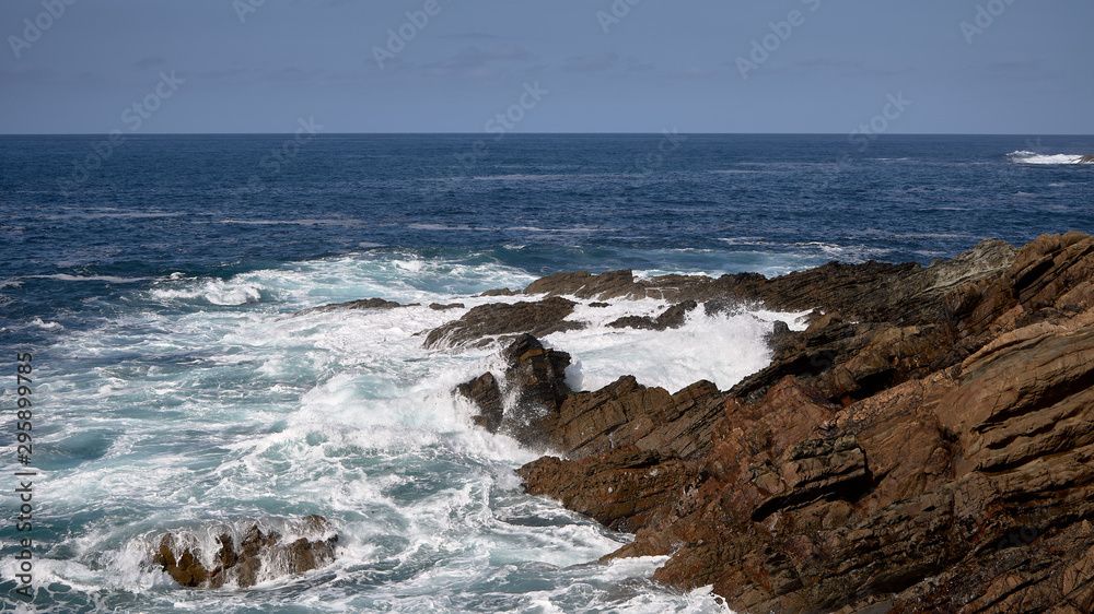 olas rompiendo contra las rocas en un acantilado