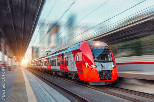 Tela Electric passenger train drives at high speed among urban landscape