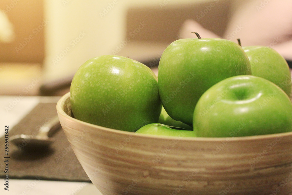 Freshness green apple in wood bowl decoration on dining table Freshness green apple in wood bowl decoration on dining table