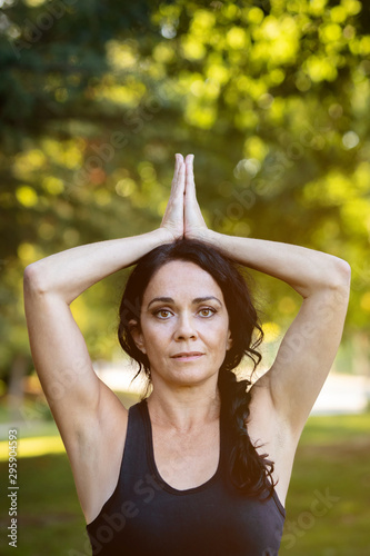Brunette woman doing yoga in a park