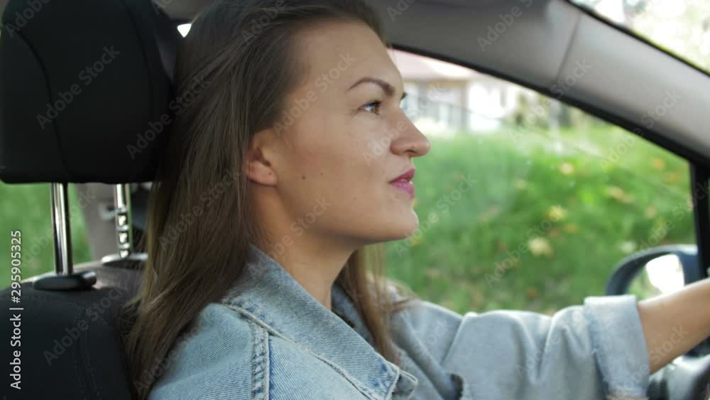Portrait of beautiful Young Woman Driving Car through big Sunny City. Camera Shot Made From the Passenger. Portrait of beautiful Young Woman Driving Car through big Sunny City. Camera Shot Made From the Passenger.