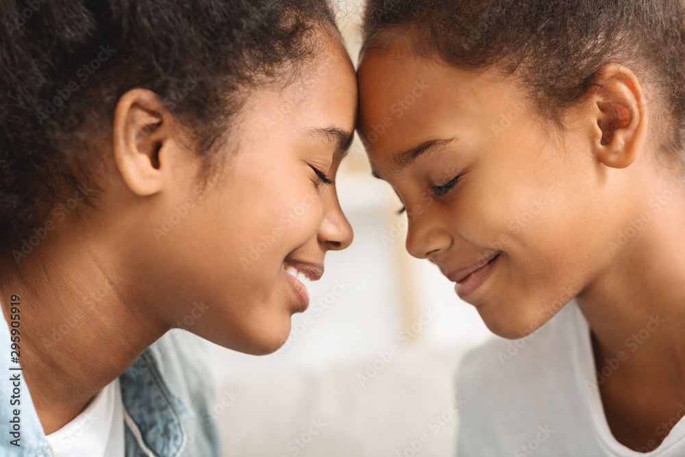 Two girls with eyes closed touching each other with foreheads Two girls with eyes closed touching each other with foreheads