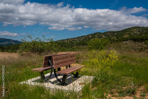 Closeup view of a wood bench isolated on the nature during a summer day with a big blue sky - Image