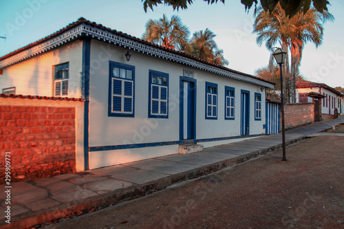 The beautiful design of the facade of a blue and white colonial style house with eaves accents on the leisure street of the historic city of Pirenópolis in central Brazil.