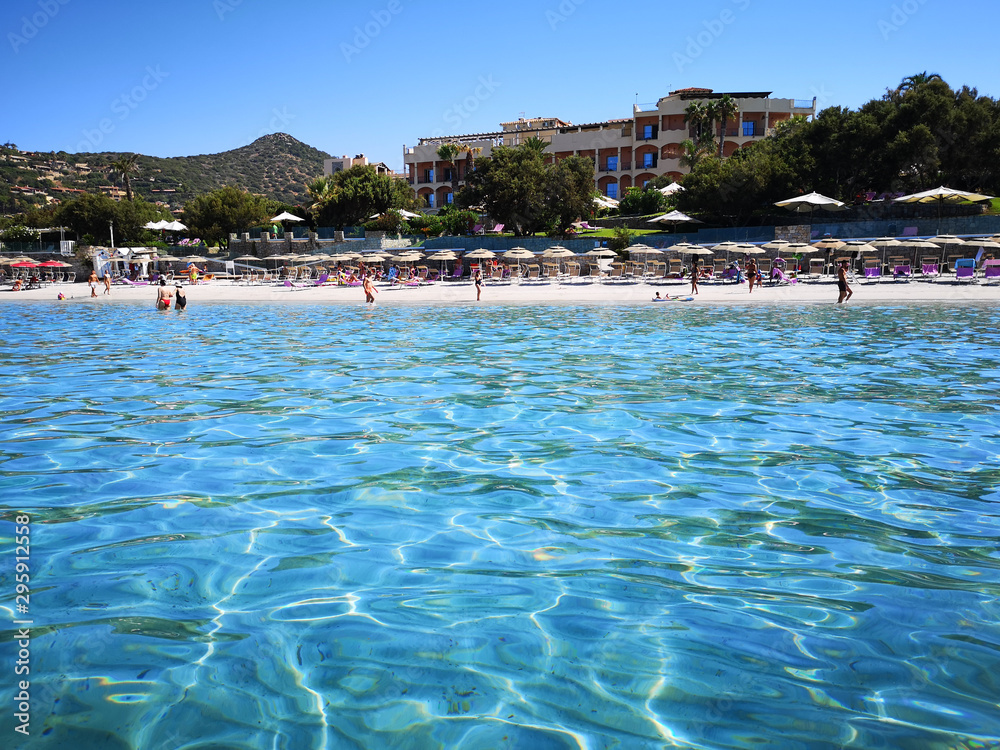 The blue clear water and white sand of a beach in Sardinia.