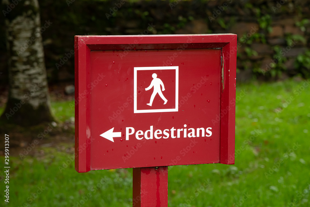 A red and white Pedestrians directional sign A red and white Pedestrians directional sign