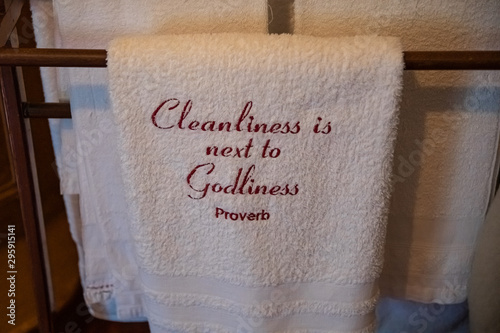 White towel with Cleanliness is next to Godliness proverb embroidered on it