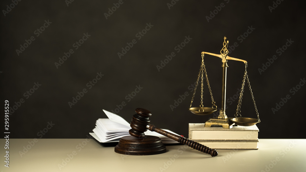 Law and Justice concept. Mallet of the judge, books, scales of justice. Gray stone background, reflections on the floor, place for typography. Courtroom theme. Law and Justice concept. Mallet of the judge, books, scales of justice. Gray stone background, reflections on the floor, place for typography. Courtroom theme.