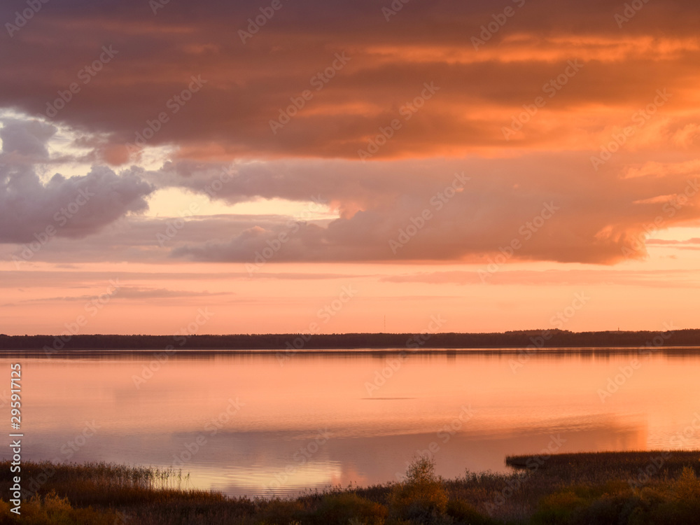 Beautiful serene colored sunset over Burtnieku lake and lake reflections of the sky above, Latvia Beautiful serene colored sunset over Burtnieku lake and lake reflections of the sky above, Latvia