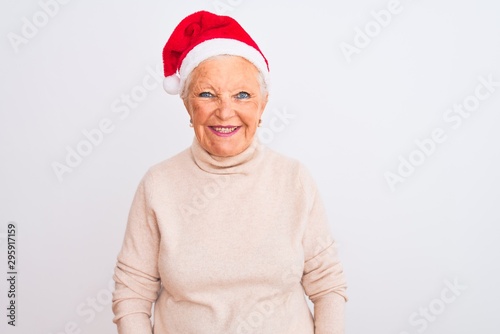 Senior grey-haired woman wearing Crhistmas Santa hat over isolated white background with a happy and cool smile on face. Lucky person.