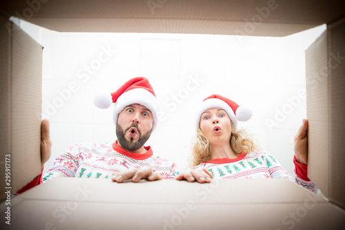 Surprised couple unpack Christmas gift box