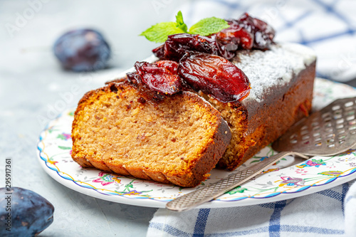 Photos Sliced plum cake with almonds and spiced plum.