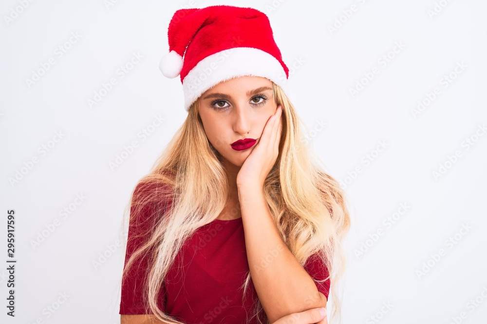 Young beautiful woman wearing Christmas Santa hat over isolated white background thinking looking tired and bored with depression problems with crossed arms. Young beautiful woman wearing Christmas Santa hat over isolated white background thinking looking tired and bored with depression problems with crossed arms.