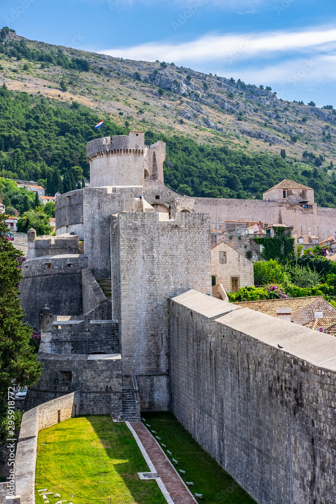 View of Dubrovnik city stone walls and hills in background, Dalmatia, Croatia, sunny summer day, the most popular touristic travel destination  