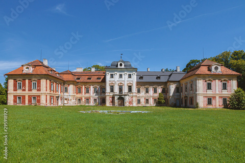 Old castle in Czech Republic. Green lawn with blue sky.