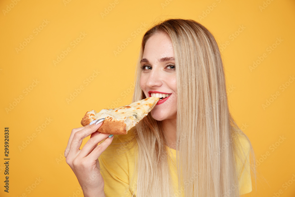 Happy girl with delicious cheese pizza isolated over the yellow background Happy girl with delicious cheese pizza isolated over the yellow background