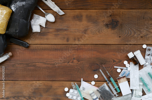 A lot of narcotic substances and devices for the preparation of drugs lie on an old wooden table photo