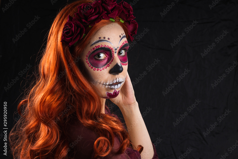 Woman with sugar skull makeup and red hair isolated on black background. Day of the dead. Halloween. Woman with sugar skull makeup and red hair isolated on black background. Day of the dead. Halloween.
