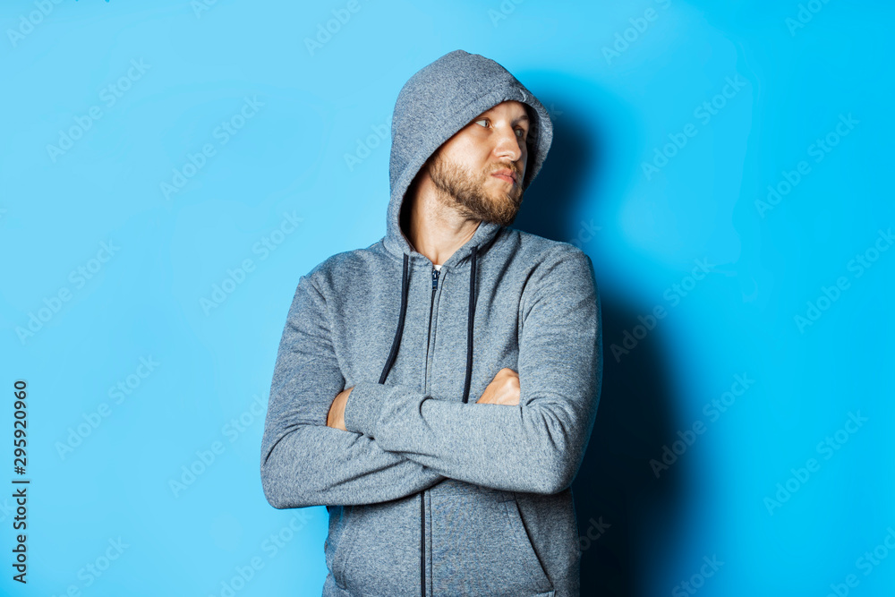 Man with a beard and a hood on a blue background Man with a beard and a hood on a blue background