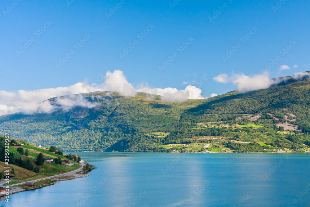 Olden, Norway, typical summer panorama of Norwegian village landscape, mountains and colorful traditional nordic houses
