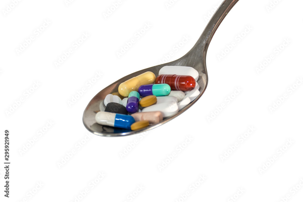 Silver spoon full of medical pills isolated on white background. Silver spoon full of medical pills isolated on white background.