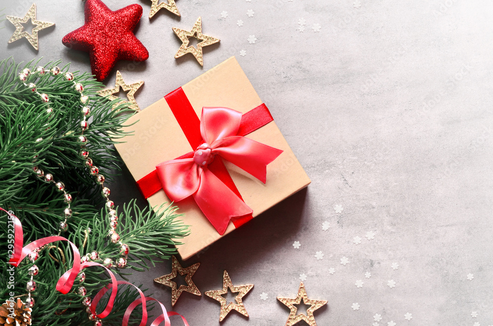 Christmas background, green pine branches, cones and gift box on grey background. Creative composition with copy space, top view. New Year's holiday, christmas.