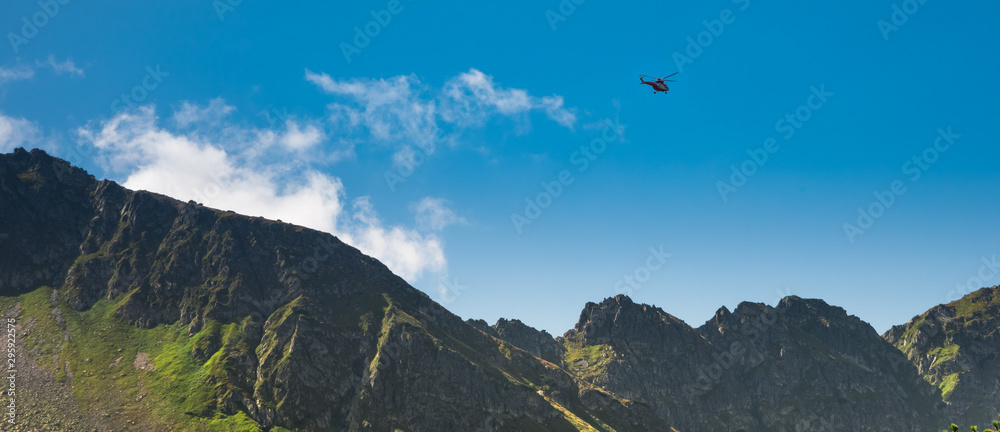 Red helicopter of TOPR (Polish mountain rescue team) during emergency action in Tatra mountains