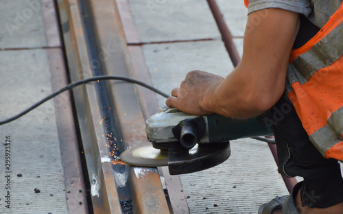 Worker grinds welded rail joint