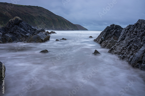 Ebbing tide exposing a rocky coast line in the morning light © NosamA