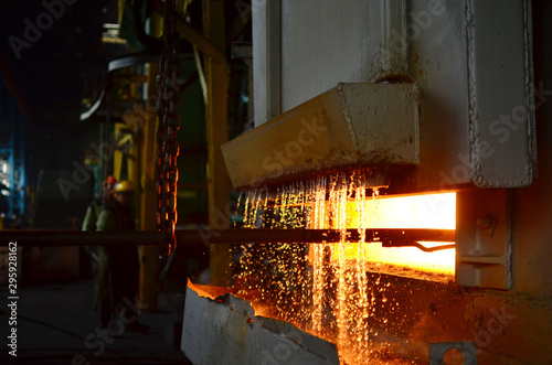 Steel quenching at high temperature in industrial furnace at the workshop of a forge plant. Process of cooling, heat treatmen. Blacksmith and metallurgical industry, hot rolling mill. Small sharpness