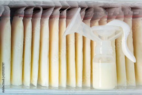Stock of breast milk frozen in storage bags and a pump bottle for a new baby of family with love in the freezer of refrigerator.