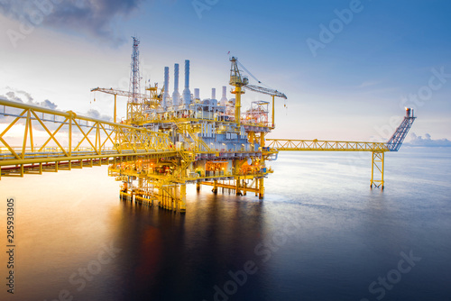 Supply boat offshore oil rig on loading operation with cloudy sky and blue ocean background. photo