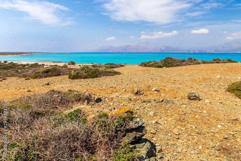 abandoned beach , rocks on coast, beautiful turquoise sea , deep blue sky with clouds and mountains on background, Mediterranean landscape