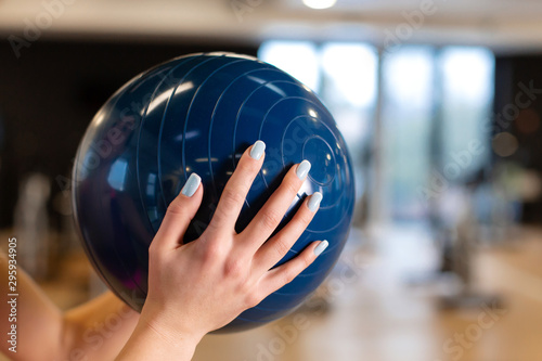 Beautiful young slim woman in sportwear doing some gymnastics at the gym with medball photo