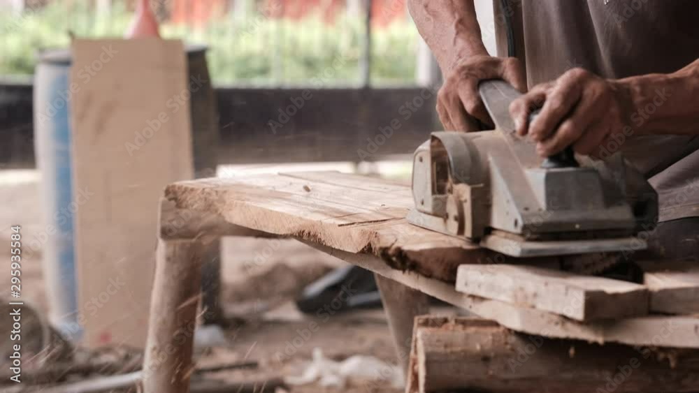 Craftsman use polishing machine to make splat is smooth and the machine split some pieces of wood in workplace during day time. Craftsman use polishing machine to make splat is smooth and the machine split some pieces of wood in workplace during day time.