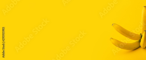 Bunch of bananas on yellow background, panoramic image with space for text, healthy food concept