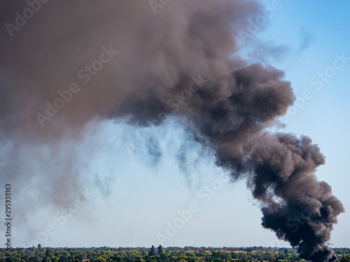 Thick black smoke from junkyard steel fire