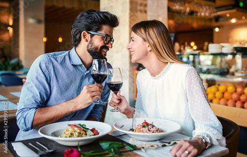 Paste and red wine. Young couple enjoying lunch in the restaurant. Lifestyle, love, relationships, food concept