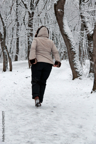Woman walking alone in the winter park outdoor