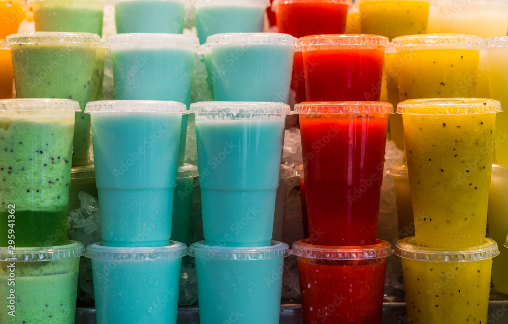 A variety of different colorful fruit smoothies at the farmers market stall A variety of different colorful fruit smoothies at the farmers market stall