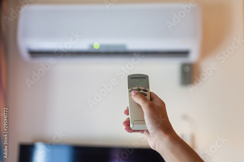 Wallpaper Mural In female hands of the remote control air conditioning in the hotel room. Cooling and airing in the hotel room. Close-up view of the use of some electrical appliances such as air conditioning. Torontodigital.ca